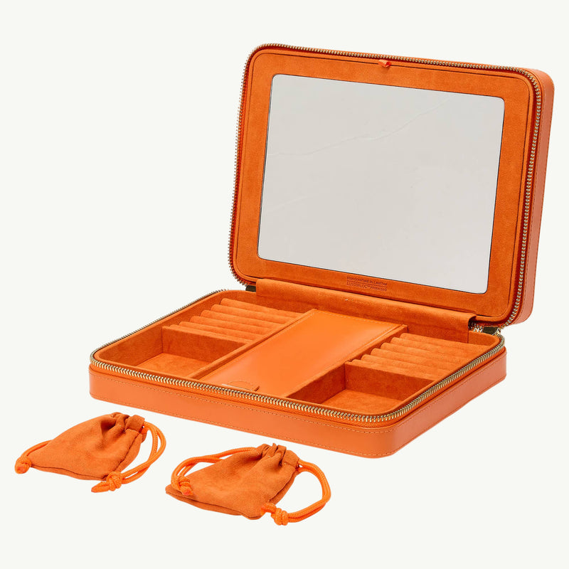 Orange jewelry case with mirror and compartments on a white background